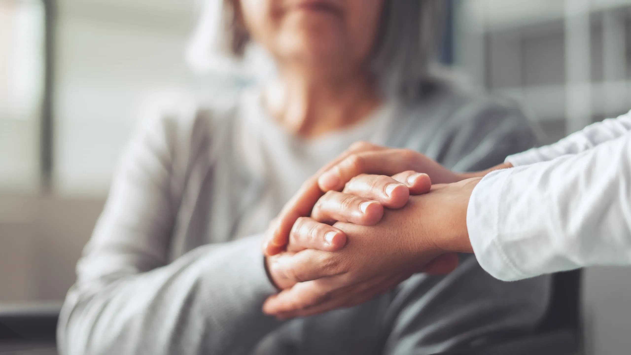 Caregiver holding resident's hands